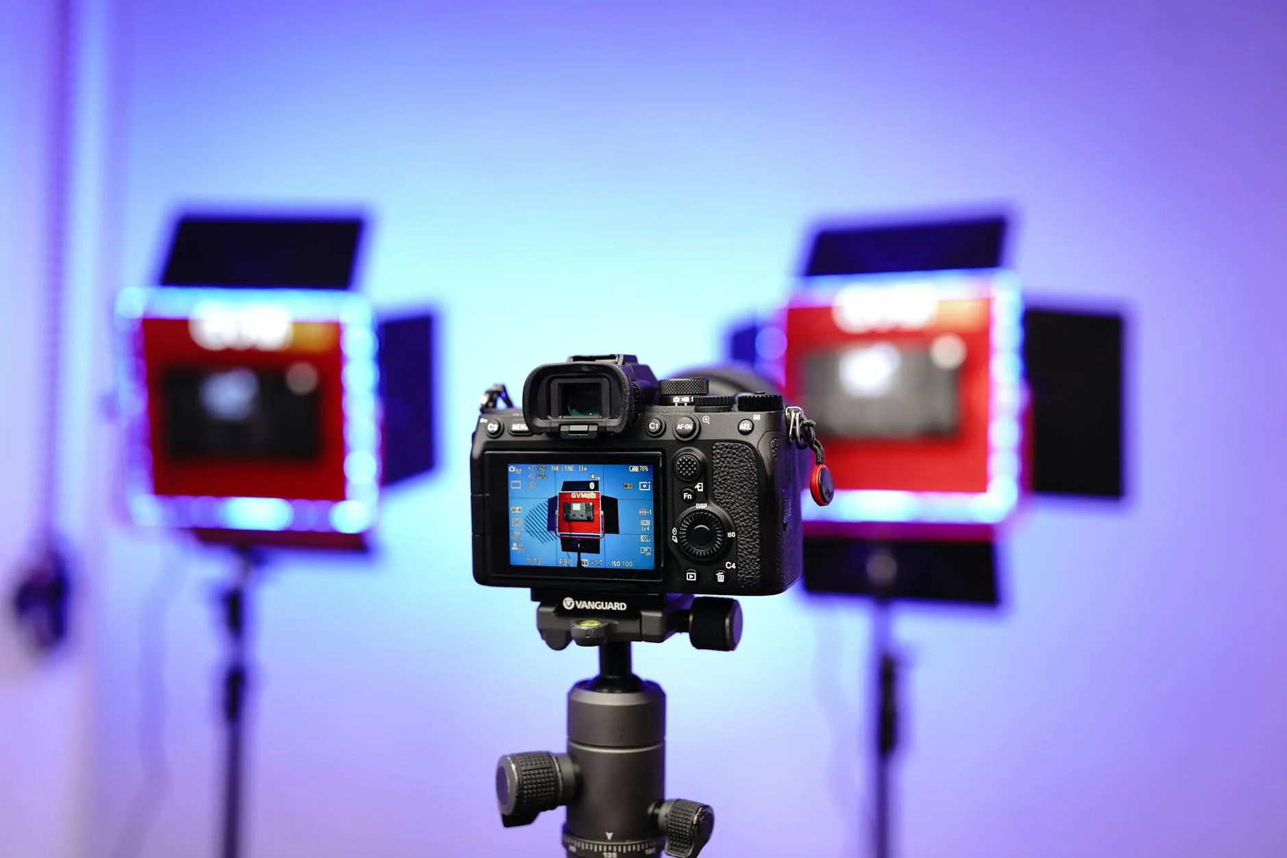 A DSLR camera on a tripod in a studio setting with illuminated lights and a professional setup.