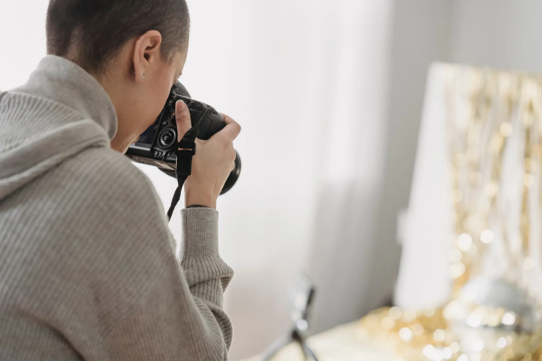 Jak zostać fotografem: młody fotograf z aparatem podczas pracy w studiu