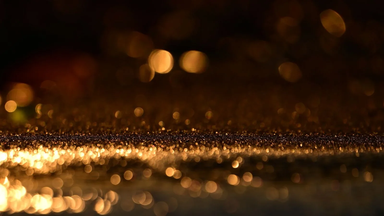 Złote refleksy i bokeh odbite od błyszczącej powierzchni