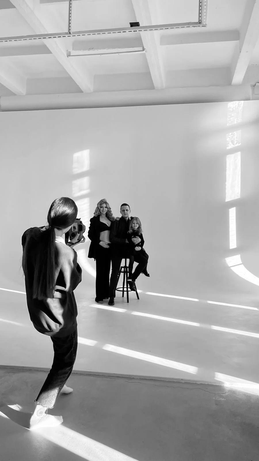Fotograf podczas sesji rodzinnej w studiu, kadr czarno-biały
