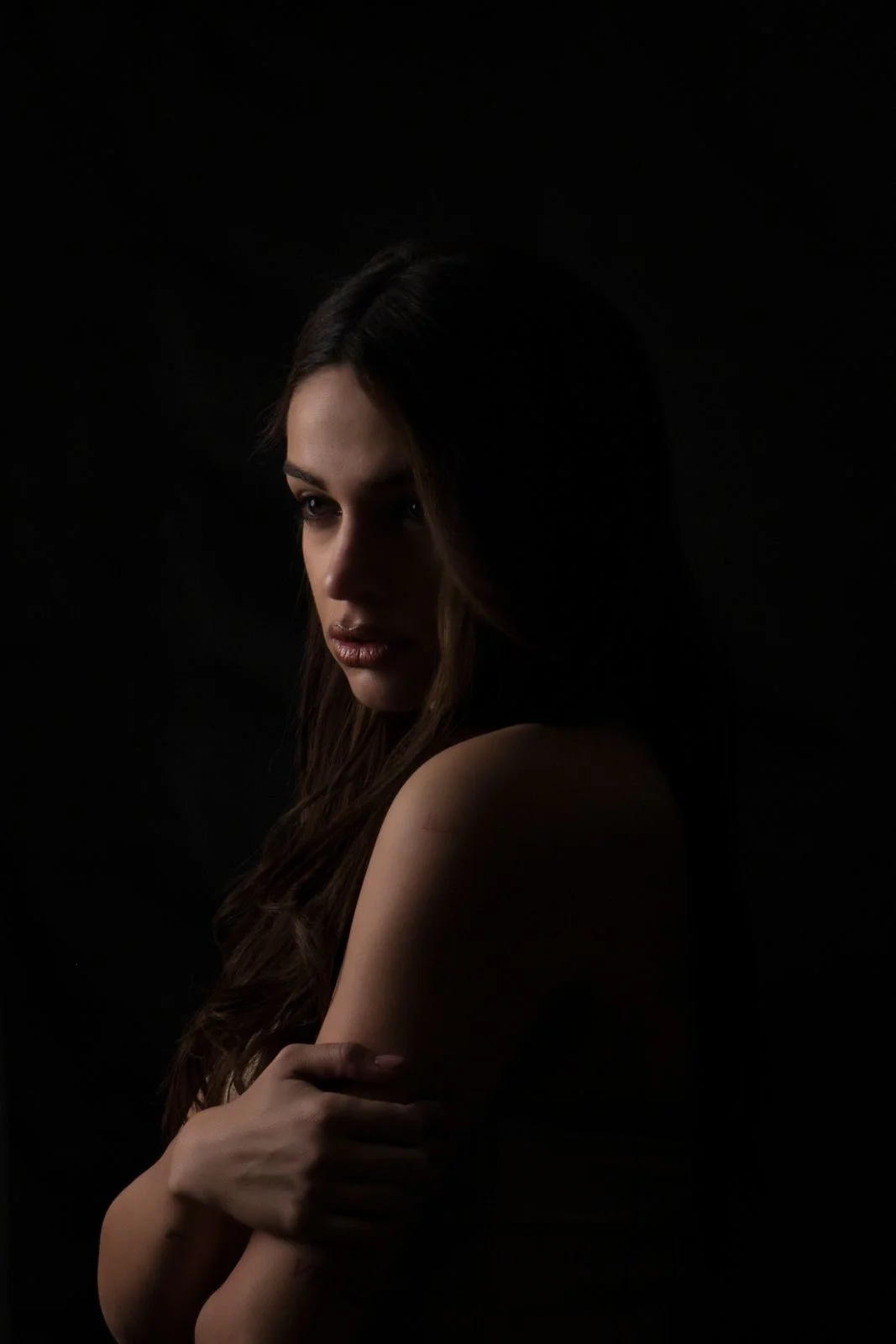 Portret low-key kobiety wyłaniającej się z ciemności