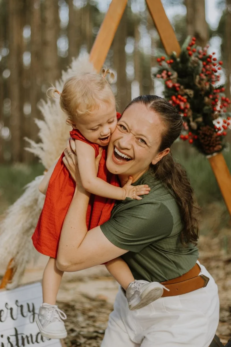 Mama przytulająca roześmianą córkę podczas świątecznej sesji